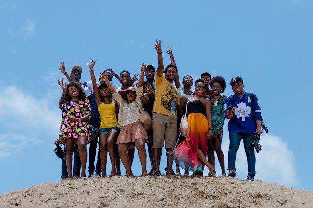 Friends cheering together on a sand dune